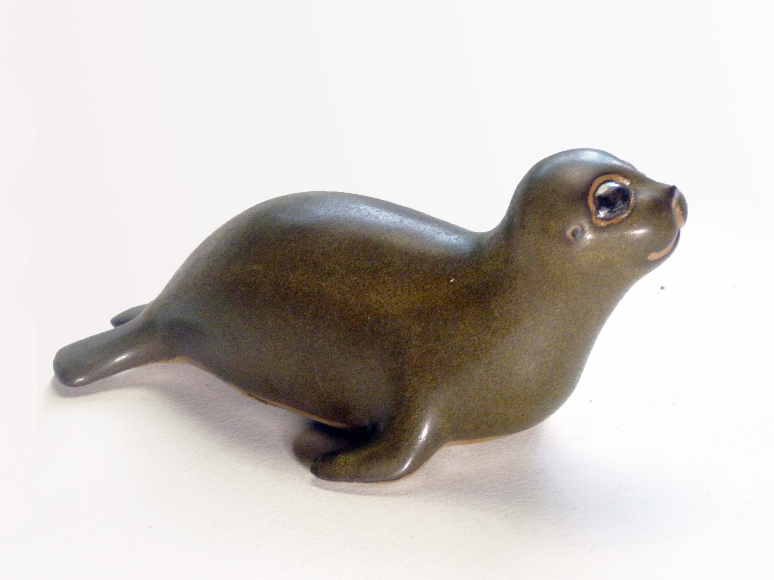 Vintage Baby Seal Early designed by Weston and Brenda Andersen ia the early version with wide eyes and short nose., Glazed in rare vintage brown glaze designed by Weston. Eyes ebony. Slip cast in red body. All handcrafted in America, 7 inches long