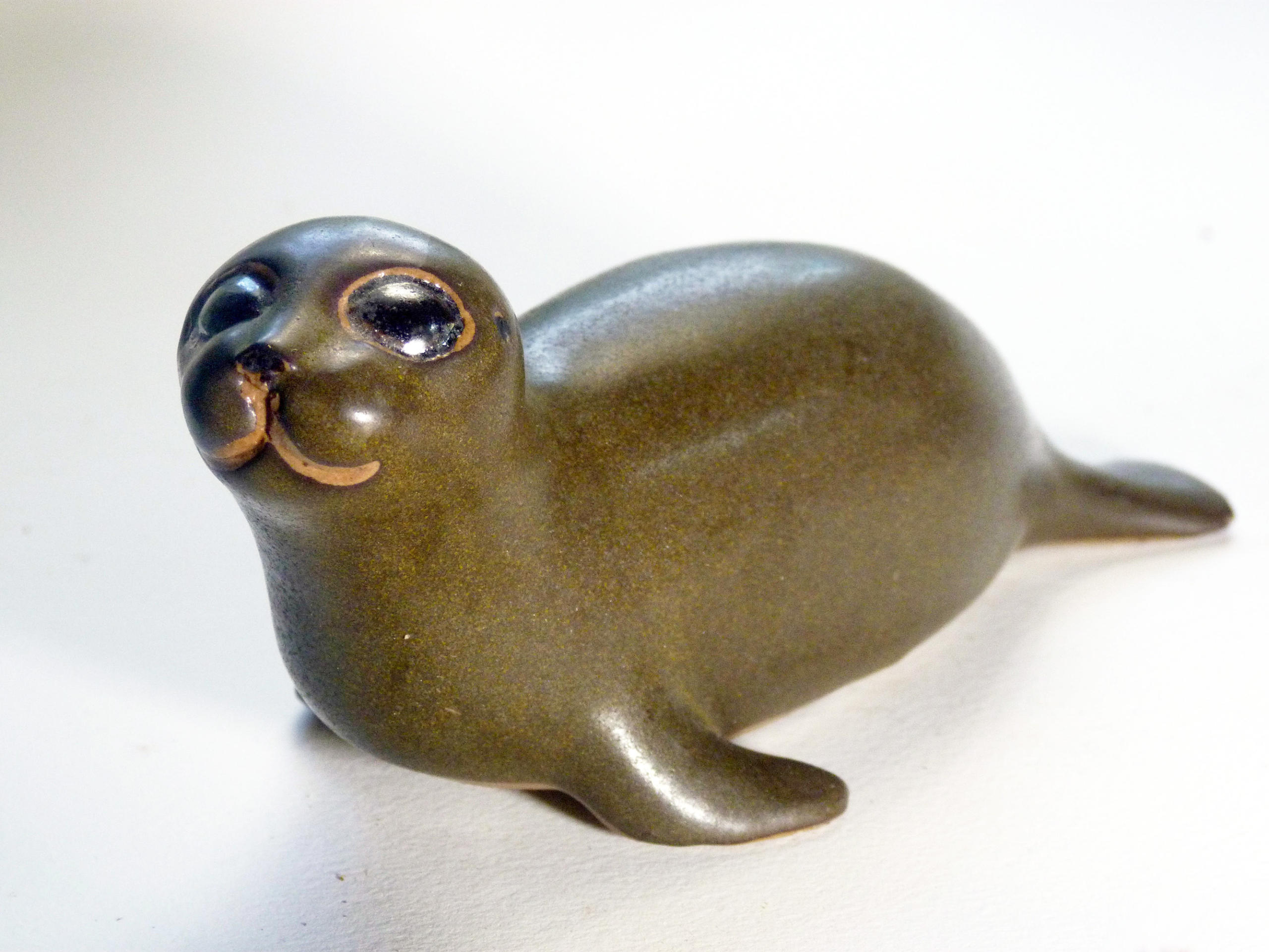 Vintage Baby Seal Early designed by Weston and Brenda Andersen is the early version with wide eyes and short nose., Glazed in rare vintage brown glaze designed by Weston. Eyes ebony. Slip cast in red body. All handcrafted in America, 7 inches long