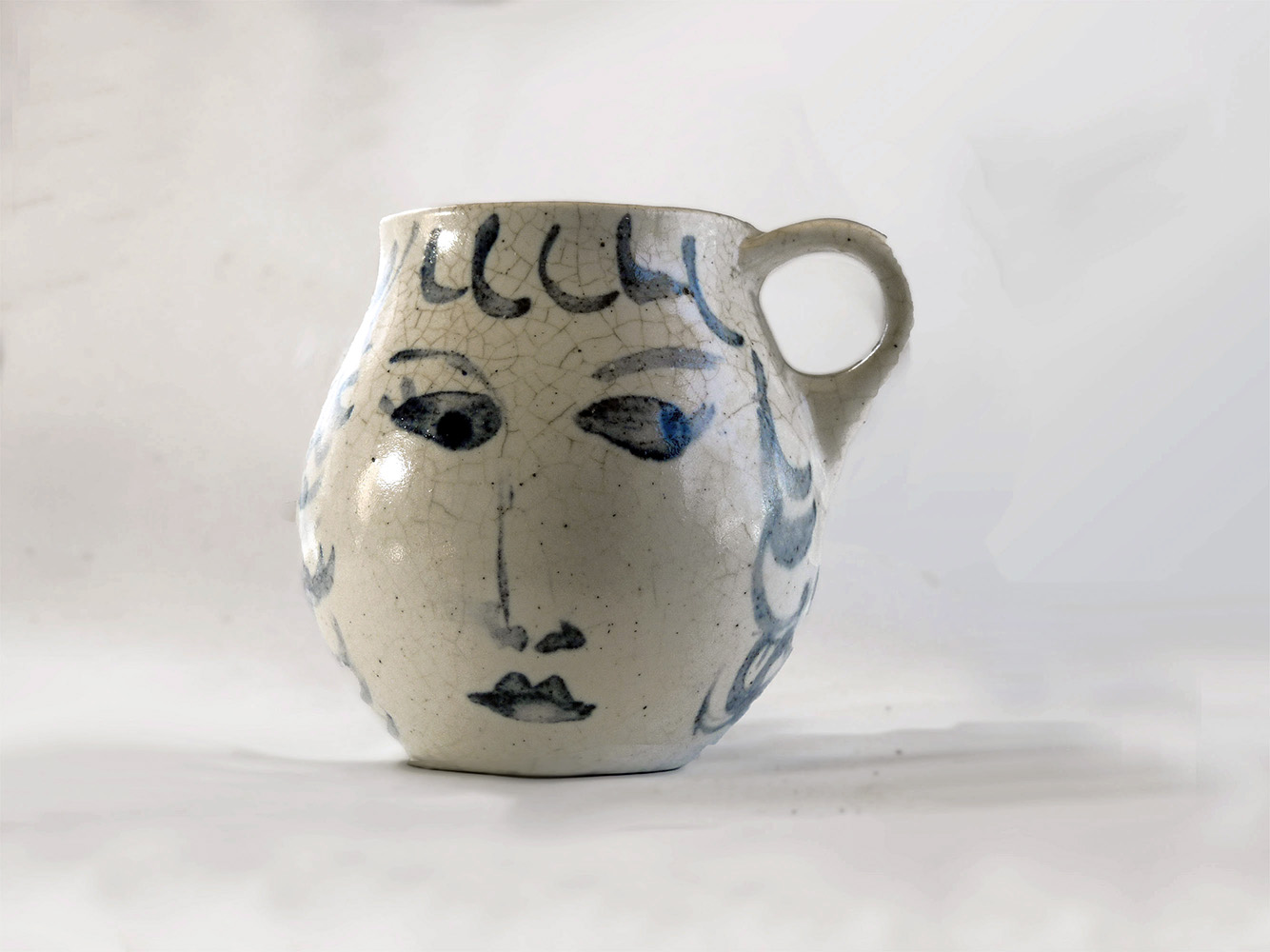 This is a one-of-a-kind mug that is part of a series of seven mugs that Brenda decorated. The mugs are delicately cast. The lip diameter is 2 inches. The body is 3.5 inches tall and wide. Out of this series of mugs, one mug is a portrait of a real person, myself, I call this mug Blue Sweet Sue, because my first name is Susan, and because one side of the mug is blue and the other sweet. I frequently sat alongside my mother when she decorated.