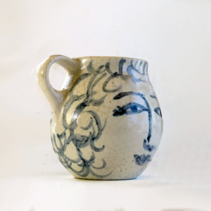 This is a one-of-a-kind mug that is part of a series of seven mugs that Brenda decorated. The mugs are delicately cast. The lip diameter is 2 inches. The body is 3.5 inches tall and wide. Out of this series of mugs, one mug is a portrait of a real person, myself, I call this mug Blue Sweet Sue, because my first name is Susan, and because one side of the mug is blue and the other sweet. I frequently sat alongside my mother when she decorated.