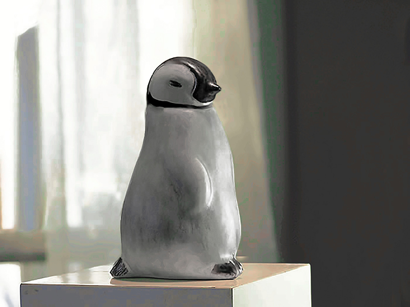 Baby Penguin Sculpture, 5 inches tall, Gray ceramic decorating color flows down the form creating variations in tone. A glossy ebony contrasts with the white matte glaze around the eyes. The Ceramic Baby Penguin is slip-cast in white stoneware and hand-crafted by American artisans,