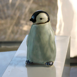 Baby Penguin Sculpture, 5 inches tall, Gray ceramic decorating color flows down the form creating variations in tone. A glossy ebony contrasts with the white matte glaze around the eyes. The Ceramic Baby Penguin is slip-cast in white stoneware and hand-crafted by American artisans,