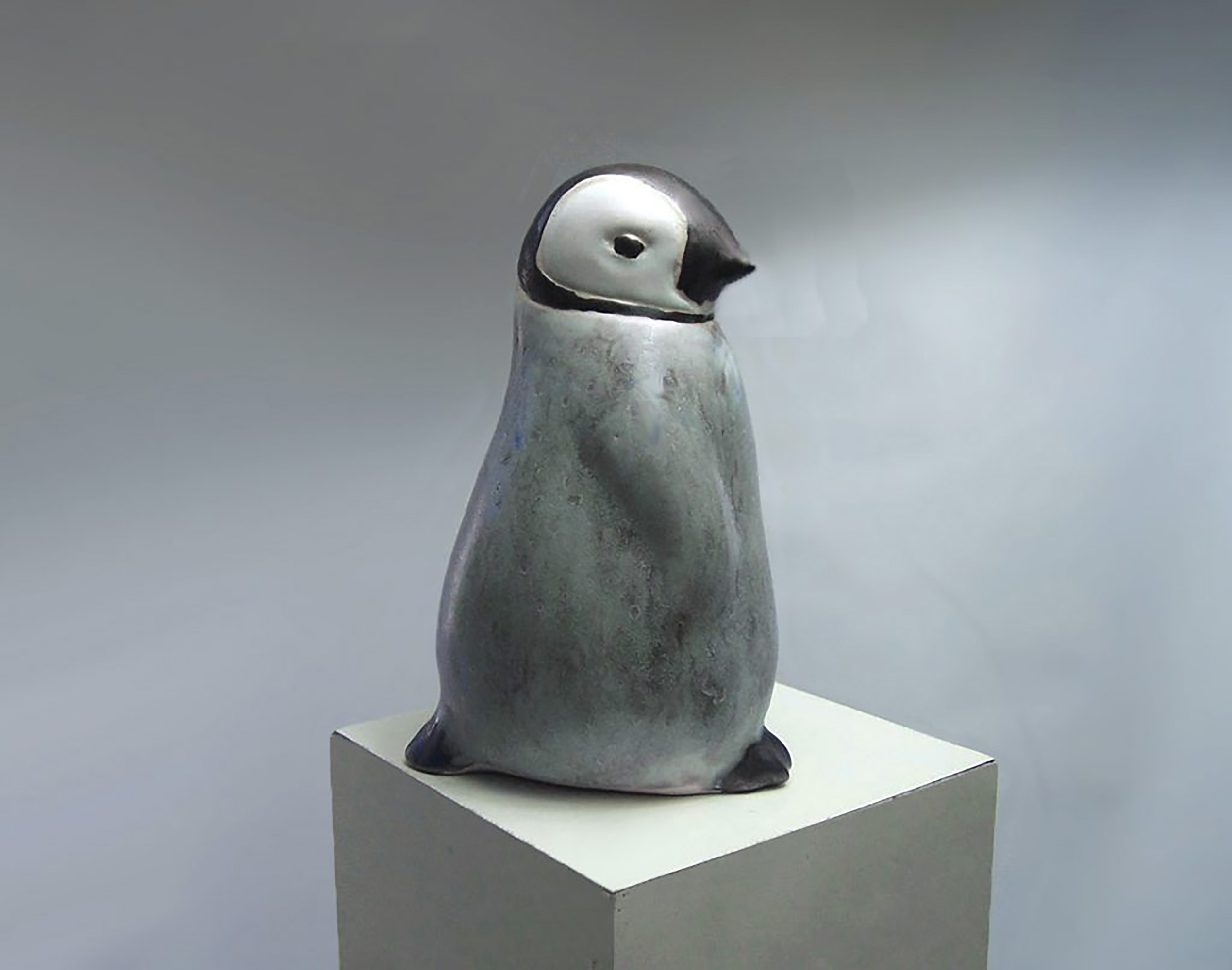 Baby Penguin Sculpture, 5 inches tall, Gray ceramic decorating color flows down the form creating variations in tone. A glossy ebony contrasts with the white matte glaze around the eyes. The Ceramic Baby Penguin is slip-cast in white stoneware and hand-crafted by American artisans,