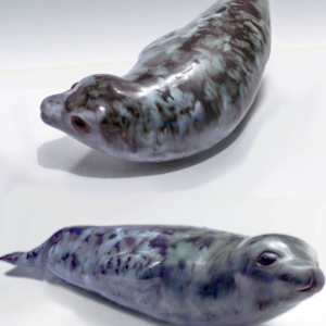 The Antarctic Seal designed by Weston and Brenda Andersen is slip cast in red stoneware, decorated in variegated tones of black and grey and dipped in our white glaze. The eyes are ebony outlined in unembellished red stoneware. The Antarctic Seal is 17 inches long, All hand made in the USA.